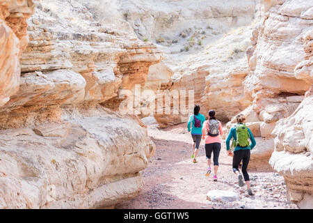 Le donne in esecuzione nel canyon indossando zaini Foto Stock