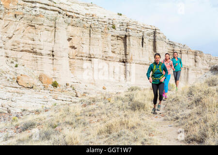 Le donne in esecuzione nel canyon indossando zaini Foto Stock