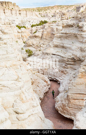 La donna in esecuzione nel canyon indossando uno zaino Foto Stock