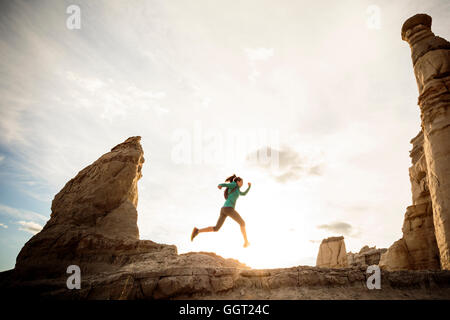 La donna in esecuzione nel canyon indossando uno zaino Foto Stock