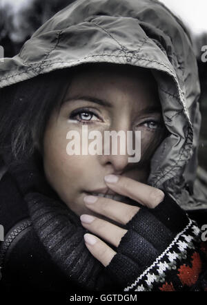 Close up della giovane donna che indossa una cappa e guanti Foto Stock
