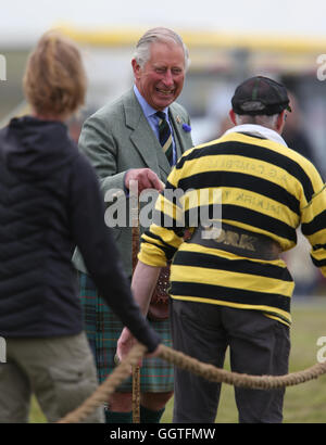 Il Principe di Galles, noto anche come il Duca di Rothesay, giudica il rimorchiatore di guerra come finale frequenta la Mey Highland Games che si sono svolti in un campo vicino a John O' Semole, Scozia, a causa di un campo saturo di acqua in Mey. Foto Stock