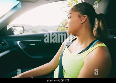 Razza mista donna fantasticando in auto Foto Stock