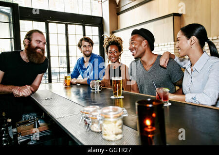 Barman sorridenti e i clienti al bar Foto Stock