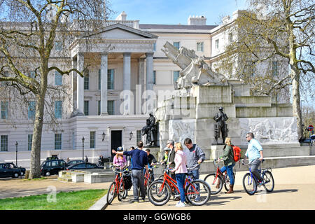 Guida turistica (rivolto) con ciclo gruppo turistico accanto al Royal Artillery Memorial a Hyde Park Corner London REGNO UNITO CON Lanesborough Hotel oltre Foto Stock