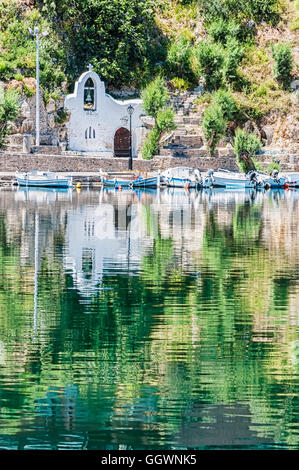 Una Chiesa riflessa nell'acqua in città balneare di Agios Nikolaos situato sul lato nord-est di Creta, Grecia. Foto Stock