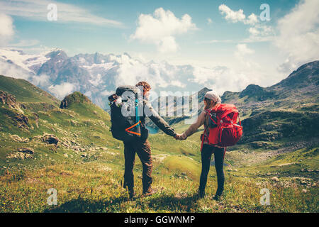 Giovane uomo e donna con zaino holding hands alpinismo Lifestyle Viaggi Vacanze estive concetto montagne e nuvole l