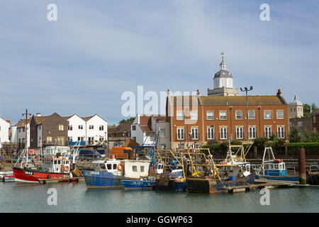 Affollato porto di pesca nella vecchia Portsmouth. Fila di barche ormeggiate nei bacini di campanatura. La torre della cattedrale in background. Foto Stock