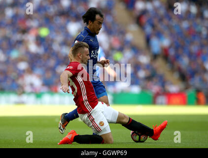 Il Leicester City's Shinji Okazaki (superiore) e il Manchester United Luca Shaw battaglia per la sfera durante la protezione comunitaria corrisponde allo stadio di Wembley, Londra. Foto Stock