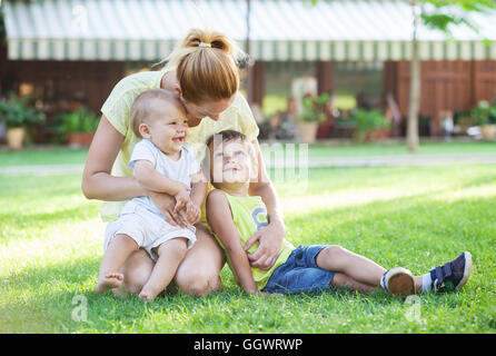 Giovane madre e due figli godendo di una splendida giornata nel parco Foto Stock