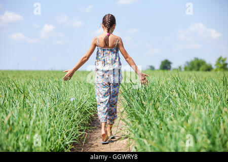 Giovane ragazza camminare attraverso il campo Foto Stock