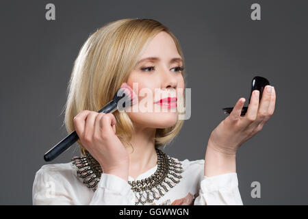 Bella donna di mezza età applicando arrossire Foto Stock