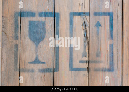 Icone fragile e questo lato in alto su un sfondo di legno Foto Stock