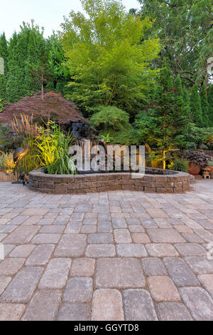 Il giardino sul retro lastricatore mattone Patio con laghetto di cascata e il paesaggio Foto Stock