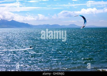 Kite boarder godendo il vento e meteo sulla spiaggia di Newborough, Anglesey, Galles, Regno Unito Foto Stock