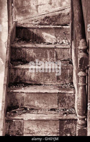 Colpo verticale di un dimenticato scala di legno interna vuota una casa abbandonata. Foto Stock