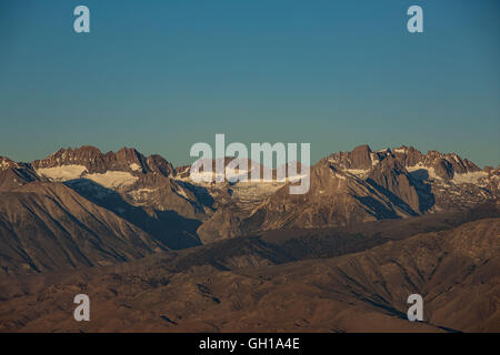 Giugno 14, 2014 - White Mountains, California, Stati Uniti - Montagne della Sierra Nevada e il Monte Whitney visto al sorgere e calare della luna da montagne bianche attraverso Owens Valley. Sotto il profilo ecologico, le montagne bianche sono come le altre gamme nel bacino e la gamma provincia; sono asciutti, ma i pendii superiore da 9.200 a 11.500 ft tenere aperte le foreste subalpine del Grande Bacino bristlecone pine. Un pino bristlecone è una delle tre specie di alberi di pino (Famiglia Pinaceae, genere Pinus, sottosezione Balfourianae). Tutte e tre le specie sono di lunga durata e altamente resistenti a condizioni climatiche avverse e terreni sconnessi. Uno dei t Foto Stock