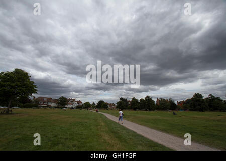 Londra, Regno Unito. 8 agosto 2016. I pedoni a piedi sotto cieli bui su Wimbledon Common Credit: amer ghazzal/Alamy Live News Foto Stock