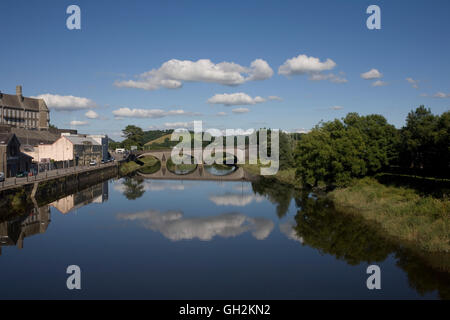 Le acque tranquille del fiume Towy in un caldo pomeriggio d'estate riflettono la A484 Carmarthen road bridge Foto Stock