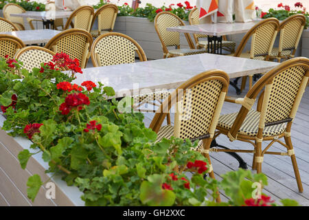 Street Cafe interior in città, tavoli e sedie, ornate di fiori, durante la stagione estiva, senza persone, luogo turistico Foto Stock