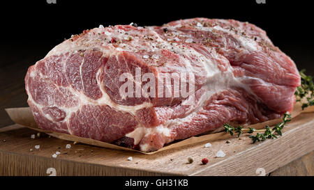 Foto di carne cruda. Collo di maiale con erbe aromatiche Foto Stock