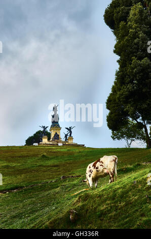 Il monumento a Simon Bolivar nel campo Boyaca, con una mucca di mangiare in primo piano nella Boyaca, Colombia. Foto Stock