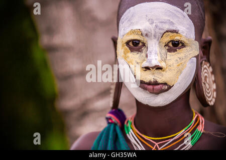 Giovane ragazza di Suri tribe con tradizionale bodypainting ed orecchini Foto Stock