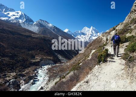 Trekker sul Passo di Pheriche con Ama Dablam in lontananza, Parco Nazionale di Sagarmatha, Distretto di Solukhumbu, Nepal, Asia Foto Stock