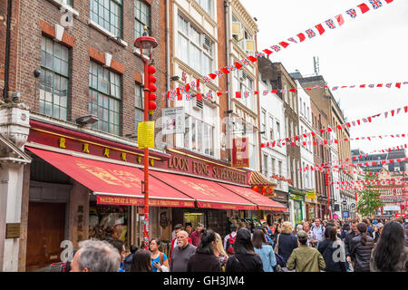 Vivace scena di strada da ristoranti cinesi di Chinatown, West End (Westminster), London, Regno Unito Foto Stock