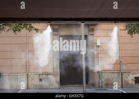 Tendaggio sprinkler gli spruzzi di acqua nebulizzata al bar sulla terrazza al fine di raffreddare la calda estate la temperatura in Spagna Foto Stock