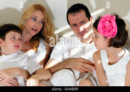 Vista ravvicinata di una famiglia di quattro seduta sul lettino e di interagire gli uni con gli altri Foto Stock