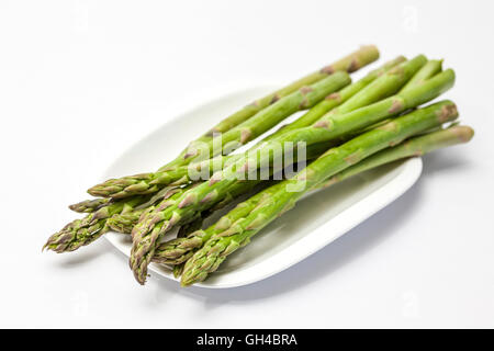 Gli asparagi verdi sul piatto bianco e lo sfondo Foto Stock