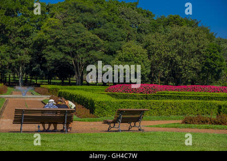 CURITIBA, Brasile - 12 Maggio 2016: alcune persone in appoggio su una panca davanti ad una fontana situata nei giardini del parco botanico Foto Stock