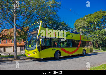 CURITIBA, Brasile - 12 Maggio 2016: green bus tour in attesa sul fermo parcheggiato nella strada accanto ad alcuni alberi Foto Stock