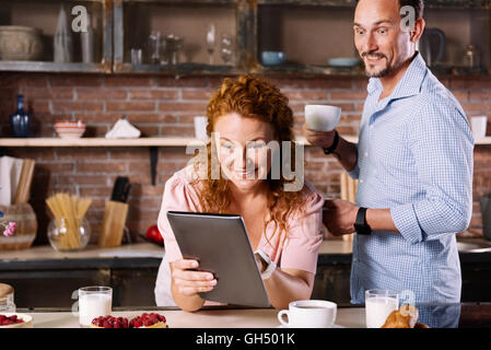 Stupito l uomo e la donna che guarda la compressa Foto Stock