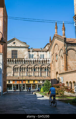 Ciclista attraversando via San Romano con San Giorgio cattedrale, Duomo di Ferrara in background. Emilia Romagna. L'Italia. Foto Stock