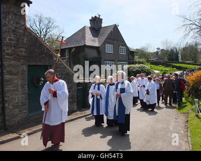 I membri del clero e processo di visitatori a benedire la ben medicazioni a Tissington, Derbyshire, Regno Unito Foto Stock