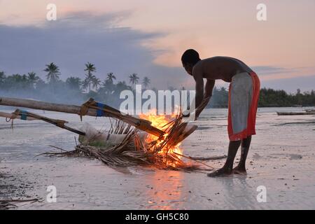 Geografia / viaggi, della Tanzania, Zanzibar, fisherman fumi con foglie di palma la sua barca, e piatto nella parte anteriore del worm di legno per salvaguardare, Dongwe Beach, Additional-Rights-Clearance-Info-Not-Available Foto Stock