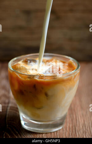 Caffè ghiacciato con il latte sul tavolo di legno Foto Stock