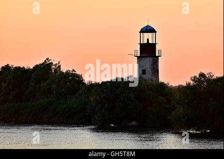 Abbandonato il vecchio e stagionato faro sunet sulle rive di un fiume Foto Stock