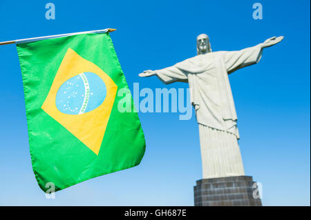 RIO DE JANEIRO - MARZO 21, 2016: bandiera brasiliana onde nella parte anteriore della statua del Cristo Redentore al Corcovado. Foto Stock