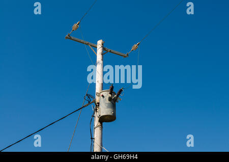 cavi di alimentazione elettrica monofase da 11 kv e trasformatore step-down su un palo in legno. Foto Stock