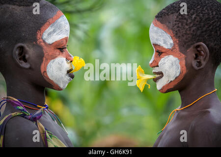 Giovane ragazza di Suri tribù giocando con i fiori. Foto Stock