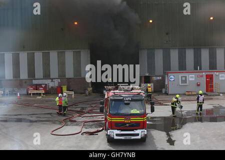 Marchwood, Hamphire, UK. 8 agosto 2016. Gli equipaggi di emergenza da Hampshire il fuoco e il servizio di soccorso e South Central servizio ambulanza rimanere presso la scena di un incendio che scoppiò subito dopo la pausa pranzo di oggi. Gli equipaggi di incendio sono state portate da un estremo di un campo come Portsmouth per affrontare il blaze all'incendio presso il centro di riciclaggio in East Road Marchwood. Otto motori Fire due aeree scale e l'incidente di unità di comando da Eastleigh stato portato a mettere fuori il fuoco. Credito: uknip/Alamy Live News Foto Stock