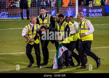 Londra, Regno Unito. 8 agosto, 2016. Protester invade il passo tenendo bandiera della Siria durante l Arabia Super Cup football match finals Al-Ahli vs Al-Hilal a Craven Cottage, Fulham Football Club Credito: Guy Corbishley/Alamy Live News Foto Stock