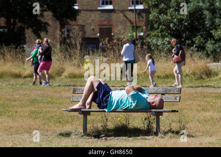 Londra, Regno Unito. Il 9 agosto 2016. Un uomo snoozes su una panchina al sole su Wimbledon Common Credit: amer ghazzal/Alamy Live News Foto Stock