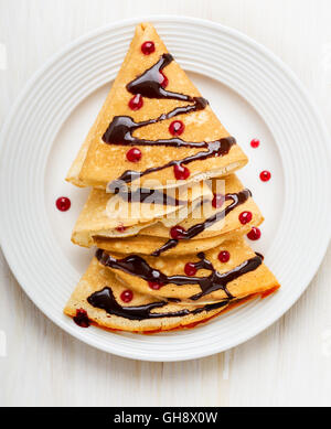 Albero di natale a forma di frittelle dolci per una vacanza divertente colazione sul tavolo bianco, vista dall'alto Foto Stock