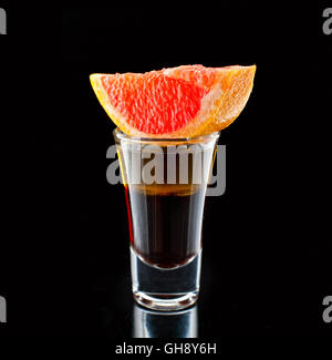 Vetro con liquore di pompelmo close-up shot su sfondo nero Foto Stock