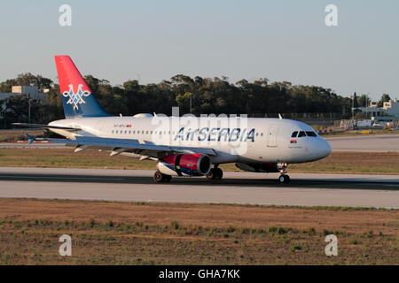 Aviazione commerciale e i viaggi aerei. Aria Serbia Airbus A319 narrowbody aereo di linea in arrivo a Malta al tramonto Foto Stock