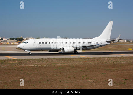 Aviazione moderna e viaggi aerei. Boeing 737 NG aereo commerciale a reazione che tassava sulla via aerea dell'aeroporto. Nessuna livrea o logo e nessun volto visibile. Foto Stock